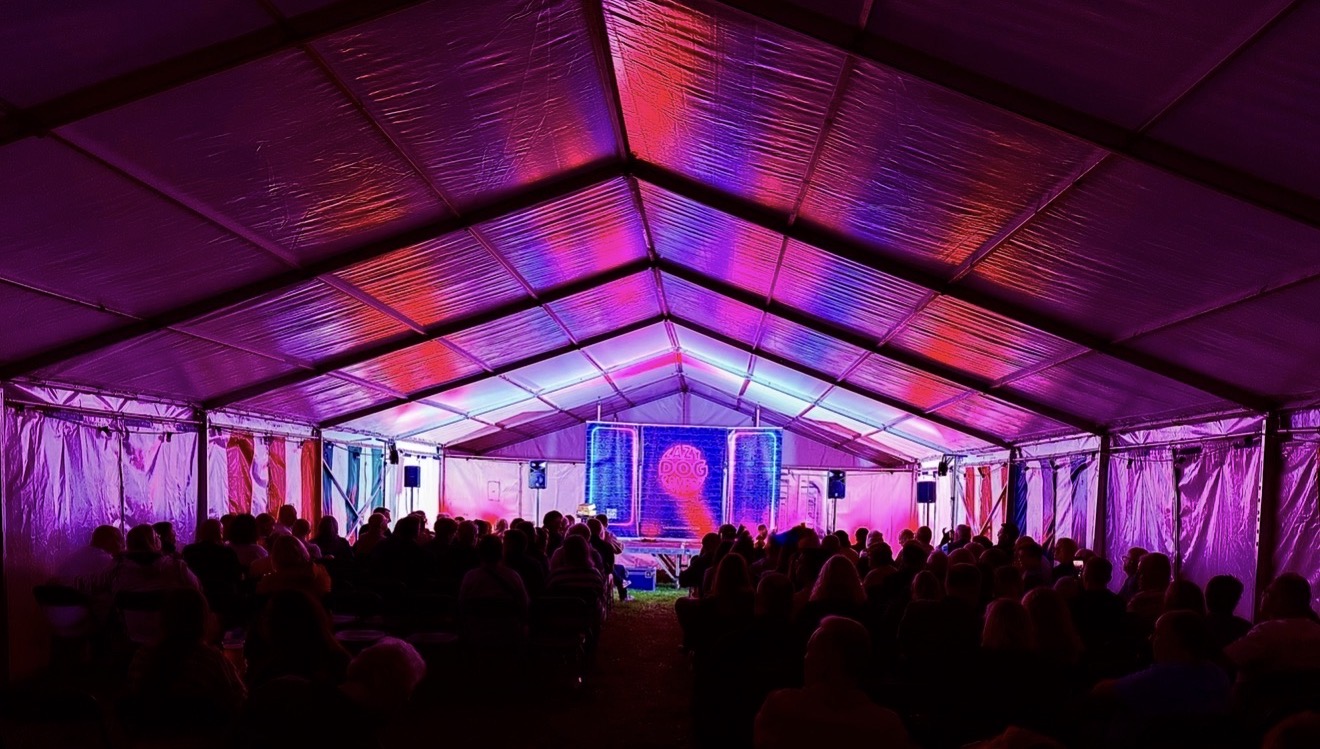 Comedy tent lit in pink and blue.